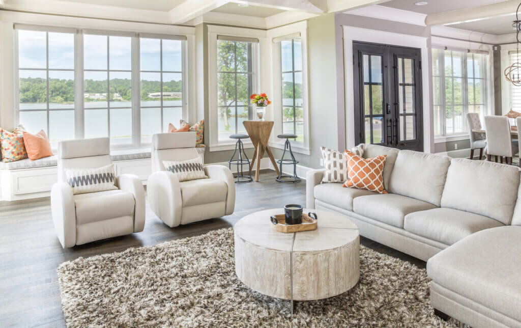 The interior of a home with Marvin Windows. These windows may be as clear as the next company's but the craftsmanship is second to none. White lounge chairs and tan couch with a picturesque view of the river can be seen in this picture.
