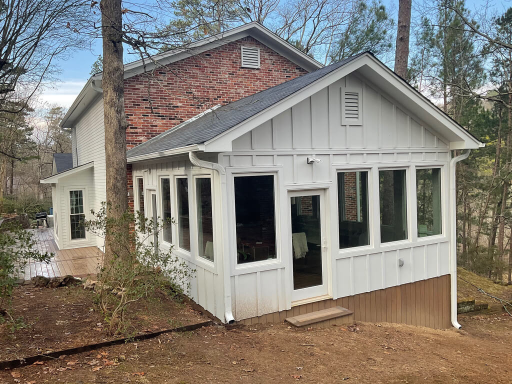 Whole House Exterior with new white sunroom off the side of the house with large windows