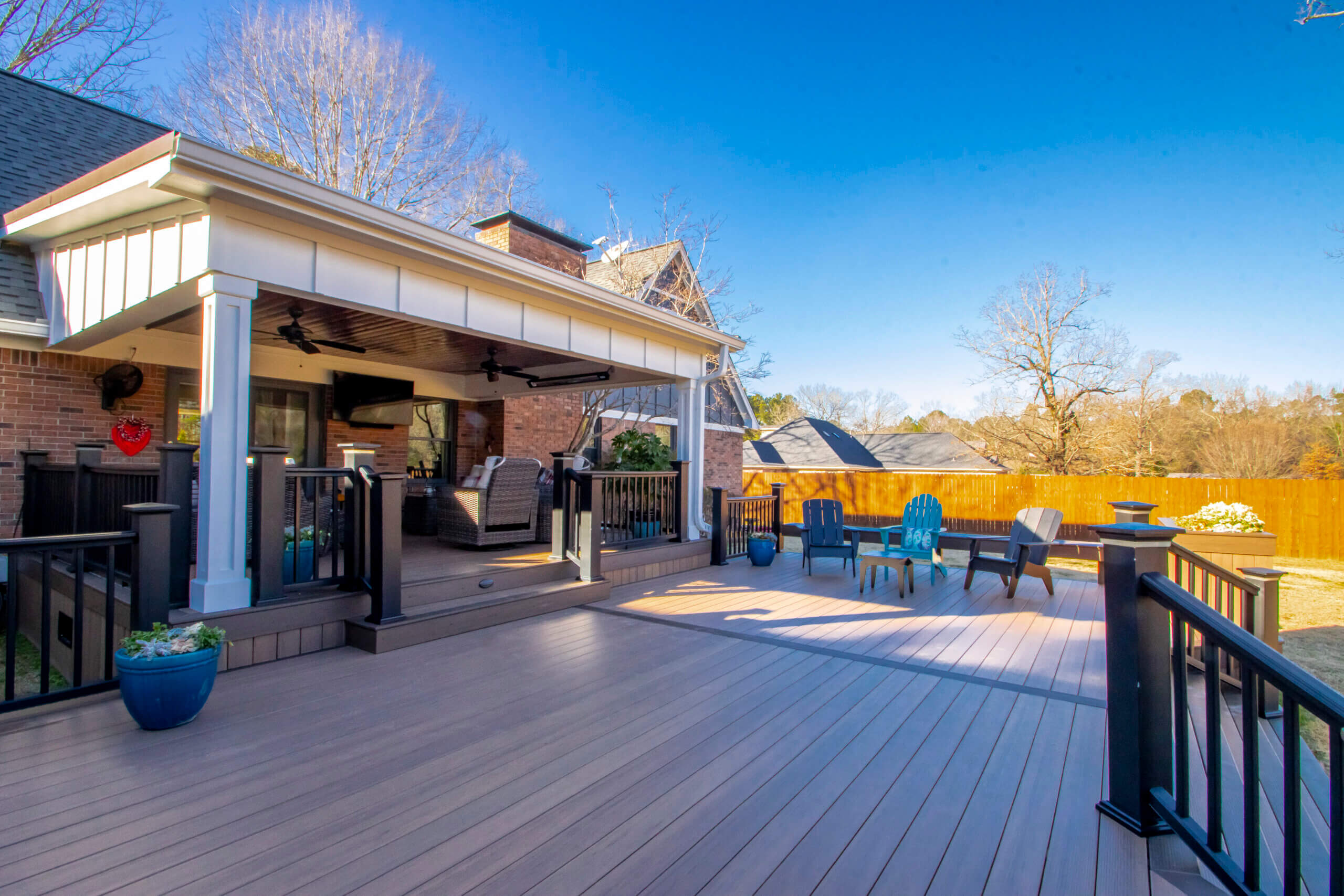 Expansive back deck off the back of a Marche home. BrownTimberTech flooring with black TimberTech rail system